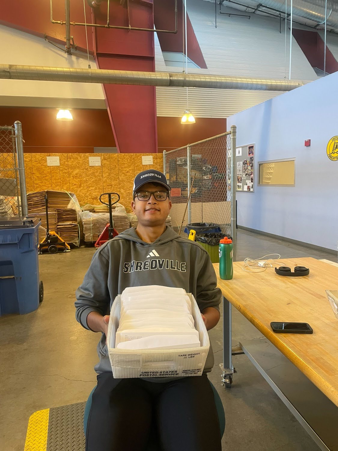 student sitting with a box of stuffed envelopes