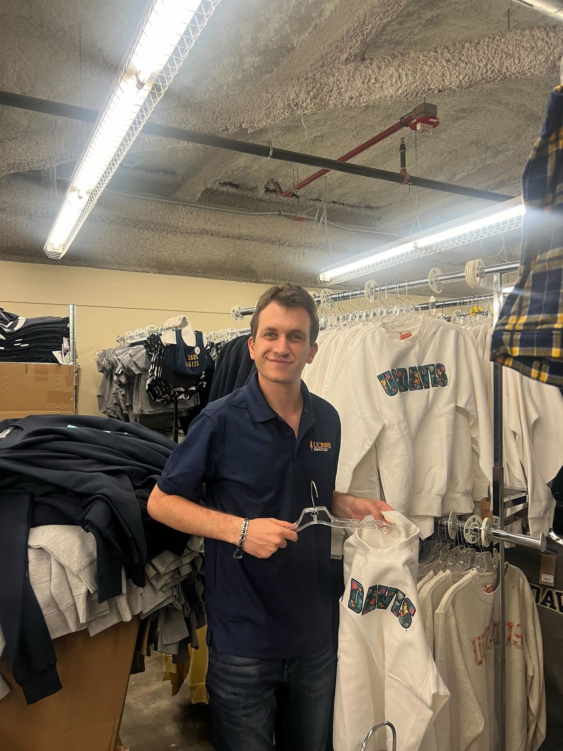 student hanging clothes in book store