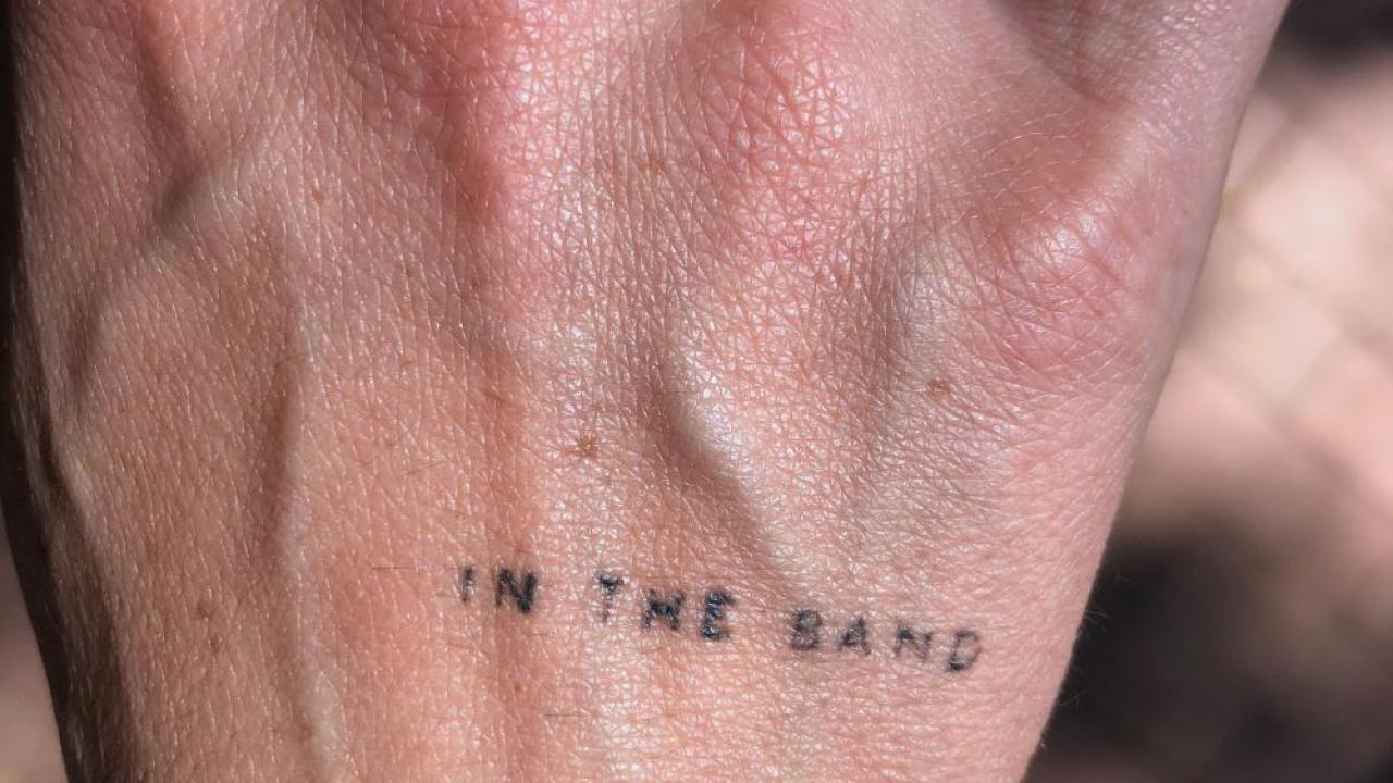 image of hand with a tattoo that says "in the band"