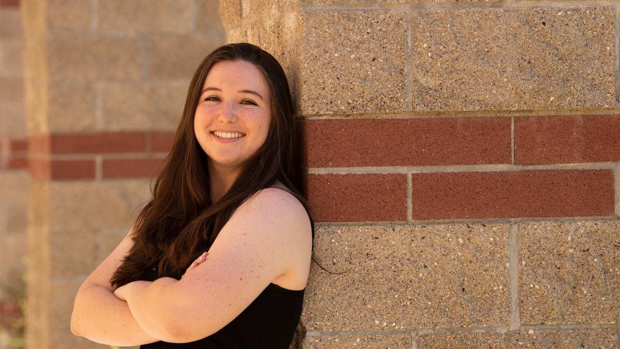 Amanda Portier leaning against a brick wall