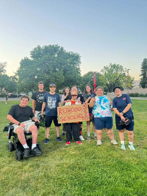 group of students holding a sign and sports equipment