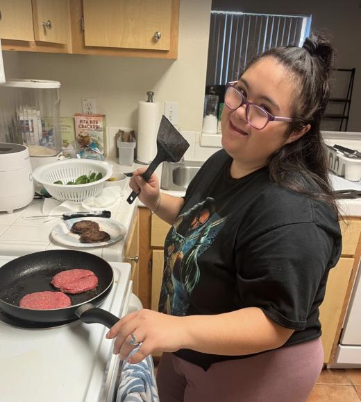 student cooking hamburgers