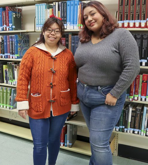Redwood SEED Scholar Karis Chun standing with her student mentor Emily Gavidia in front of a library bookshelf